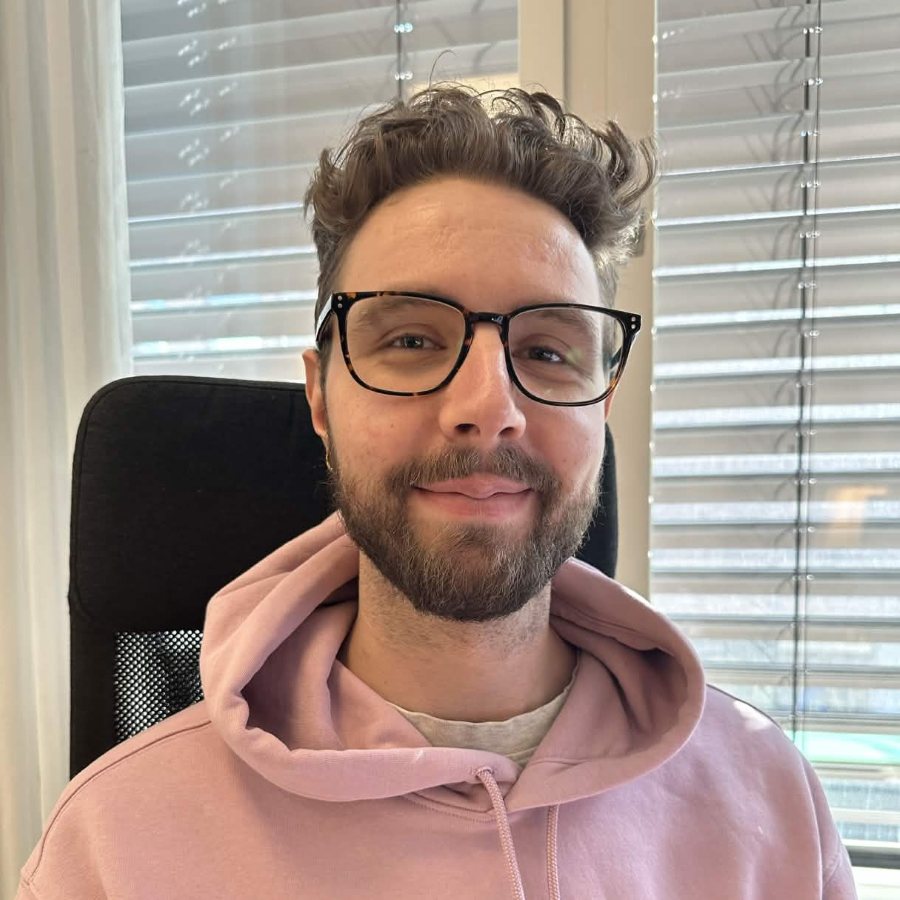 Caspian in a pink hoodie, smiling at the camera
